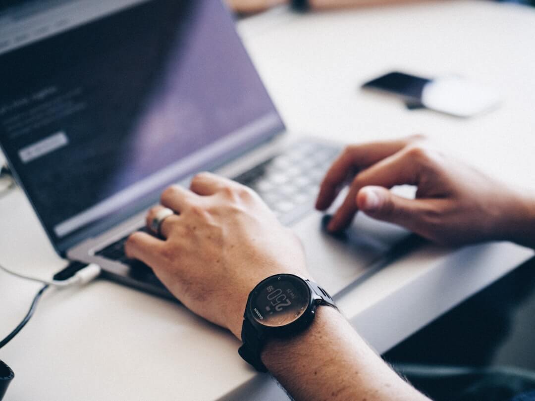 Photo of runner at computer with Garmin smartwatch